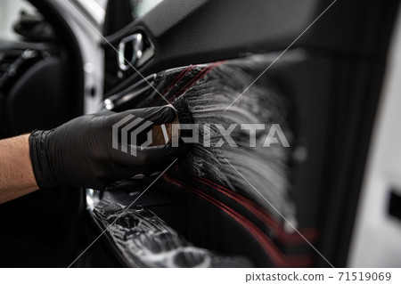 Car detailing studio worker cleaning leather car interior upholster Car detailing studio worker cleaning leather car interior upholster 71519069