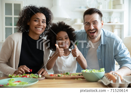 Head shot portrait happy multiracial family with kid in kitchen 71520614