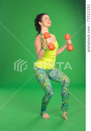 Fitness with dumbbell on green background Fitness with dumbbell on green background 71521352