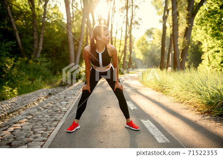 Morning training in park, woman in headphones Morning training in park, woman in headphones 71522355