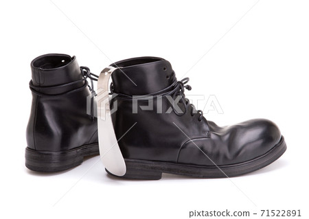 Metal Shoe spoon. Shoe spoon and large black leather boots. Metal Shoe spoon. Shoe spoon and large black leather boots. 71522891