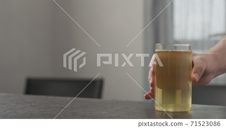 Slow motion take kombucha highball glass from concrete countertop with copy space 71523086