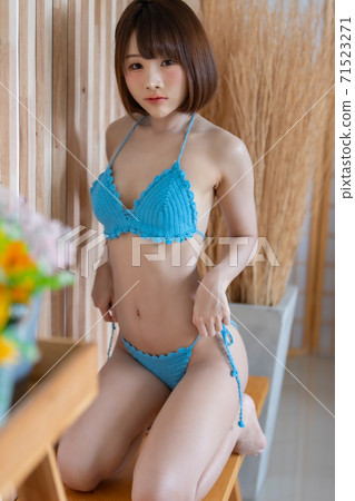 Portrait of young pretty sexy Asian woman wearing blue bikini in her room. Portrait of young pretty sexy Asian woman wearing blue bikini in her room. 71523271