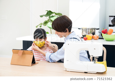 一個女人用縫紉機縫製兒童口罩 一個女人用縫紉機縫製兒童口罩 71523362