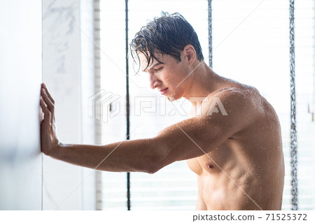 Handsome young man taking hot shower in bathroom - Stock Photo