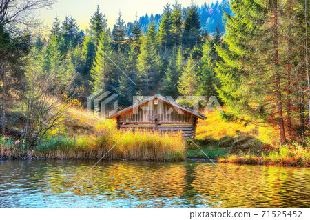 Awesome view of Wagenbruchsee (Geroldsee) lake with wooden hut and Karwendel mountains  71525452