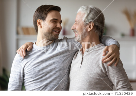 Close up overjoyed mature father with adult son hugging 71530429