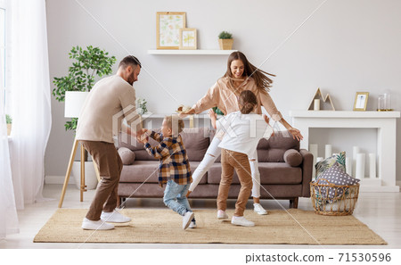 happy family mother father and children dancing at home  . 71530596