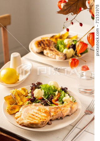 Pork entrecote on the bone with pumpkin and salad Pork entrecote on the bone with pumpkin and salad 71531978