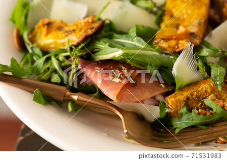 Salad with arugula, pumpkin, prosciutto and parmesan Salad with arugula, pumpkin, prosciutto and parmesan 71531983