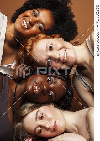 young pretty caucasian, afro, scandinavian woman posing cheerful together on brown background, lifestyle diverse nationality people concept 71532259