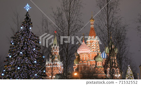 St. Basil's Cathedral on Red Square against the backdrop of Christmas decorations and passers-by. 71532552