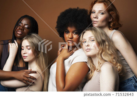 young pretty african and caucasian women posing cheerful together on brown background, lifestyle diverse nationality people concept 71532643