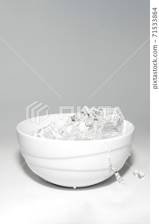 water splashes in a glass with ice on a white background water splashes in a glass with ice on a white background 71533864