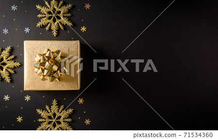 Top view of golden christmas boxes and snowflake on black background with copy space for text. Black Friday Sale, Banner, poster composition. 71534360