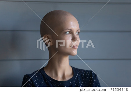 Concentrated young female diagnosed with oncology looking forward with courage 71534548