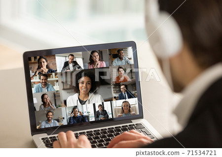 Young businessman holding working video call with diverse colleagues. 71534721