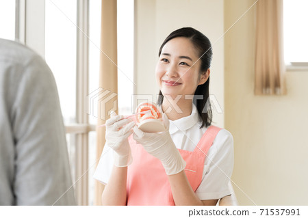 A woman teaching brushing teeth A woman teaching brushing teeth 71537991