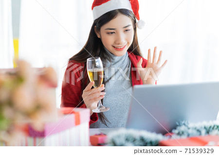 Two Asian women celebrating Christmas through computer screen 71539329