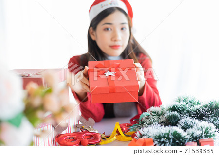 Beautiful Asian woman preparing for Christmas at home Beautiful Asian woman preparing for Christmas at home 71539335
