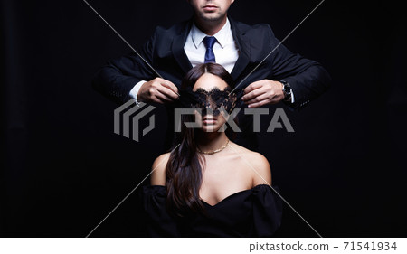 beautiful woman in mask and man in a suit beautiful woman in mask and man in a suit 71541934