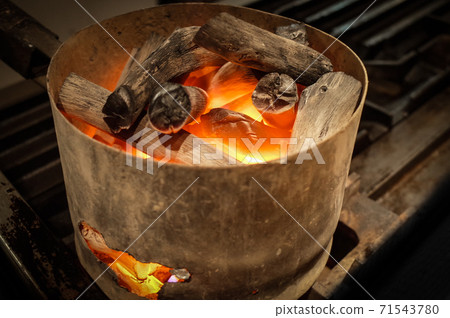 A blazing charcoal fire A blazing charcoal fire 71543780