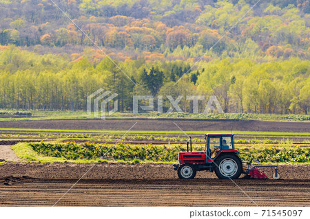 Tractor to cultivate fields / Around Niseko area in Hokkaido Tractor to cultivate fields / Around Niseko area in Hokkaido 71545097