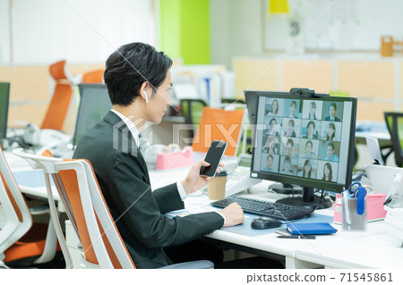 A young man having a webinar alone in an empty office 71545861