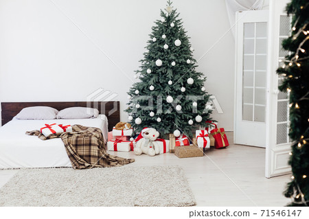 New Year's card bedroom interior with red bed decor and Christmas tree with gifts New Year's card bedroom interior with red bed decor and Christmas tree with gifts 71546147