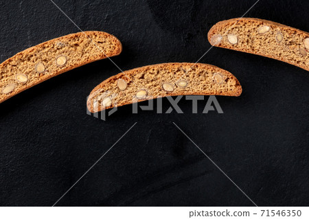 Biscotti. Traditional Italian almond cookies, shot from above on a black background Biscotti. Traditional Italian almond cookies, shot from above on a black background 71546350