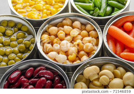 Canned vegetables in opened tin cans on kitchen table. Non-perishable long shelf life foods background Canned vegetables in opened tin cans on kitchen table. Non-perishable long shelf life foods background 71546859