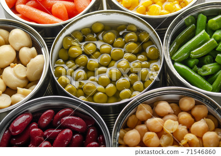 Canned vegetables in opened tin cans on kitchen table. Non-perishable long shelf life foods background Canned vegetables in opened tin cans on kitchen table. Non-perishable long shelf life foods background 71546860