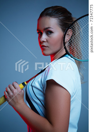 Beautiful handicap woman practicing in badminton isolated on blue background in neon light 71547775