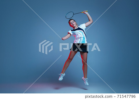 Beautiful handicap woman practicing in badminton isolated on blue background in neon light 71547796