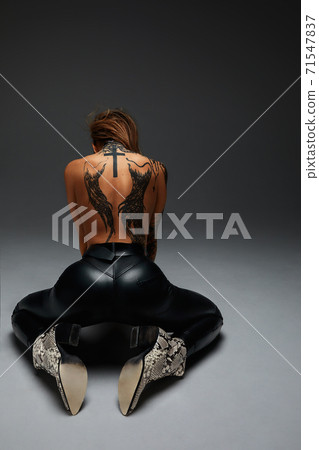 the back of a young girl with a tattoo . Tanned beautiful girl with a tattoo on the entire back the back of a young girl with a tattoo . Tanned beautiful girl with a tattoo on the entire back 71547837