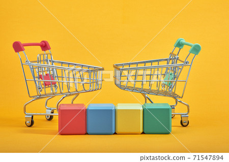 empty wooden cubes mockup style, copy space with shopping trolleys on yellow background. Colourful blocks template for creative design, place for text empty wooden cubes mockup style, copy space with shopping trolleys on yellow background. Colourful blocks template for creative design, place for text 71547894