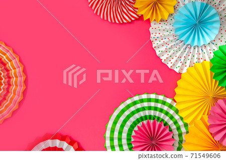 Colorful paper rosette and birthday garlands. Decorating for a party. Round, bright and color decoration. Pink background. 71549606
