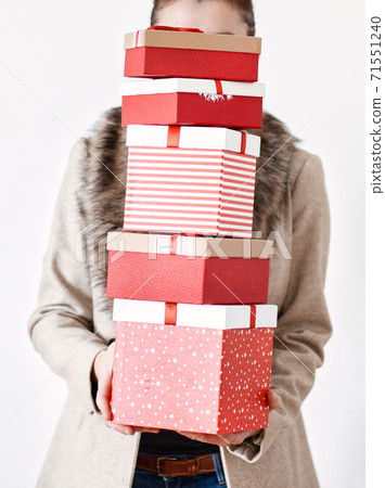 woman returning home from shopping holding pile of christmas present boxes 71551240