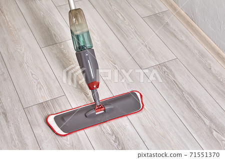 Cleaning lady cleans flat using mop with microfiber cloth and special liquid. 71551370