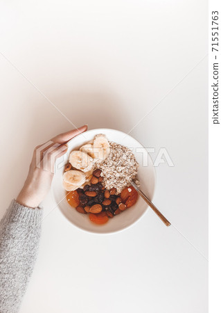 Carbohydrate healthy breakfast. Oatmeal with dried fruits on a white plate. View from above Carbohydrate healthy breakfast. Oatmeal with dried fruits on a white plate. View from above 71551763
