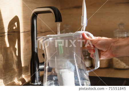 Water filter jug in kitchen sink, filling up. Water filter jug in kitchen sink, filling up. 71551845