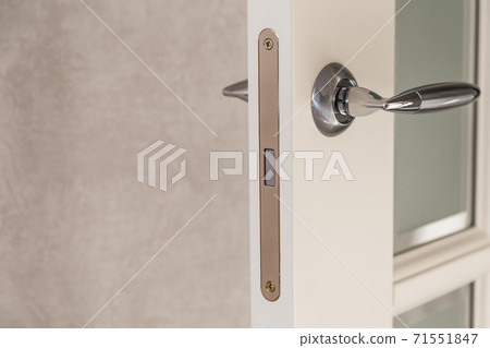 Wooden door with contemporary magnetic latch on modern interior. 71551847