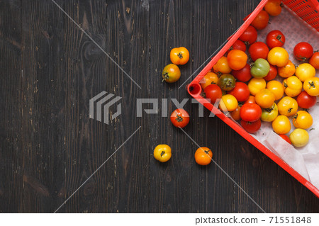 Tomatoes in a box. Ripe tomatoes in a container. Top view, flat lay, still life on black wooden background 71551848