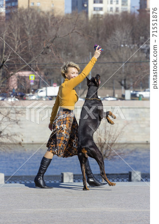 Pretty adult woman with dog outdoors 71551876