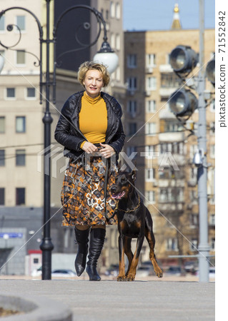 Pretty adult woman with dog outdoors Pretty adult woman with dog outdoors 71552842