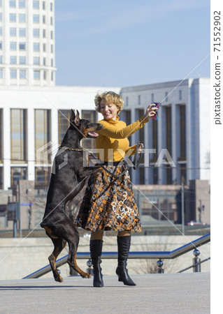 Pretty adult woman with dog outdoors Pretty adult woman with dog outdoors 71552902