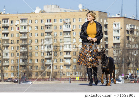 Pretty adult woman with dog outdoors Pretty adult woman with dog outdoors 71552905