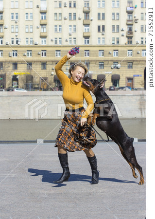 Pretty adult woman with dog outdoors Pretty adult woman with dog outdoors 71552911