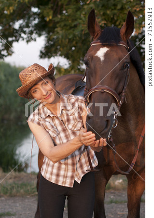 Young woman hold horses head Young woman hold horses head 71552913