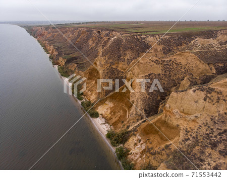 Aerial Shot of clay hills with canyons near the Black sea at Misty Autumn weather. Stanislavs mountains, Kherson region, Ukraine Aerial Shot of clay hills with canyons near the Black sea at Misty Autumn weather. Stanislavs mountains, Kherson region, Ukraine 71553442